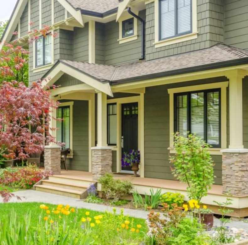 Beautiful craftsman home with fresh grey exterior paint and lush landscaping