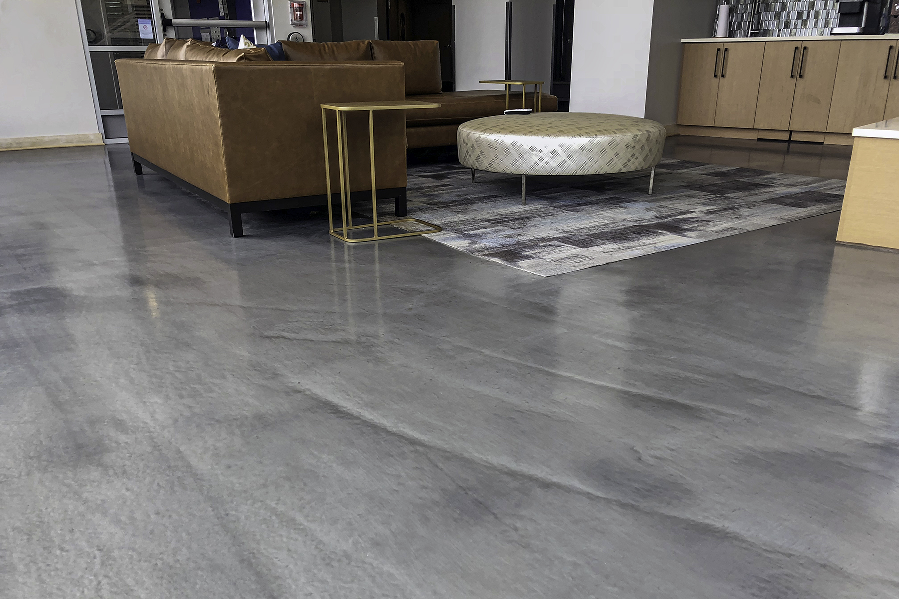 Commercial epoxy floor coating with high-gloss grey finish in a modern office space