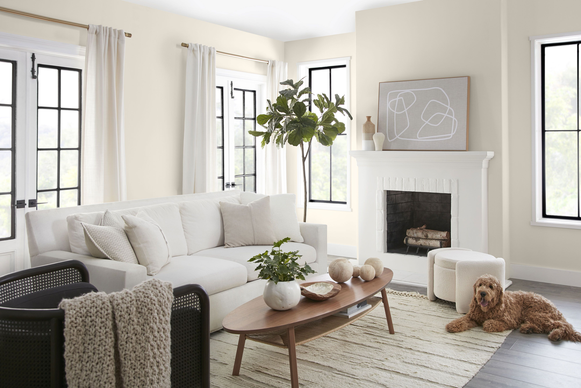 Bright residential living room with warm cream interior paint, white fireplace and modern furnishings